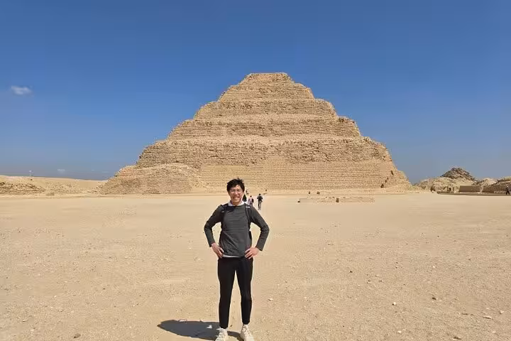Traveler posing at the Step Pyramid of Djoser in Saqqara on full-day Giza, Memphis and Saqqara tour
