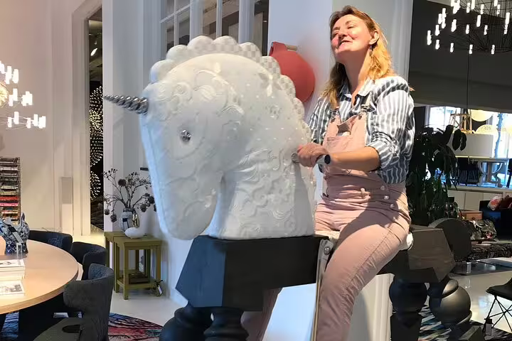 Traveler on quirky unicorn sculpture in Amsterdam concept store, part of Your Own Amsterdam random adventure experience