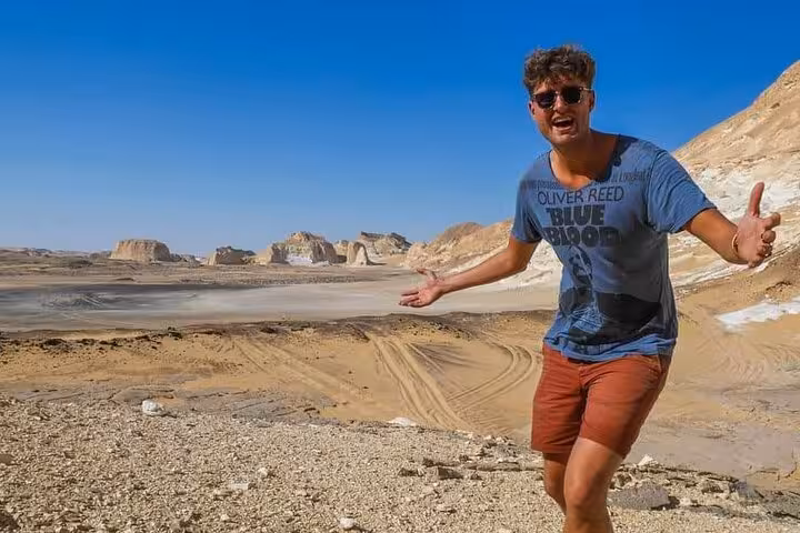 Traveler posing in Egypt’s White Desert on Bahariya Oasis 3-day eco camping safari with rock formations