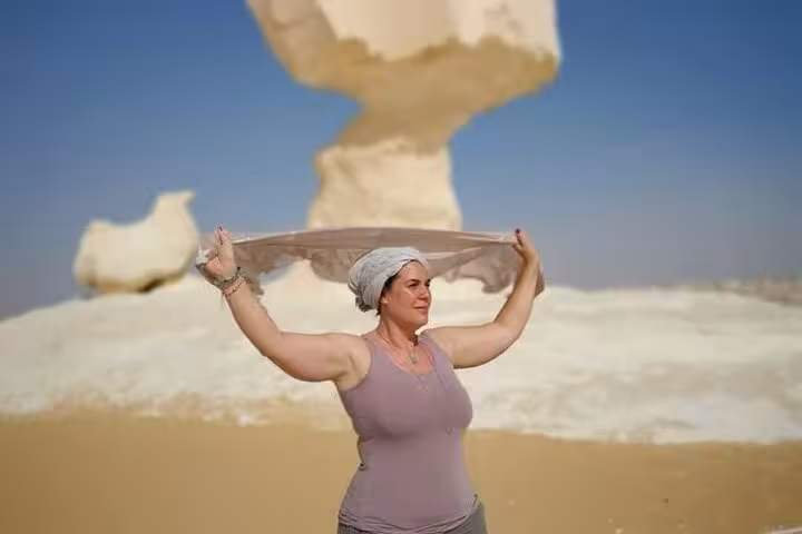 Traveler posing by White Desert mushroom rock on private 2-day Black and White Desert camping tour Egypt