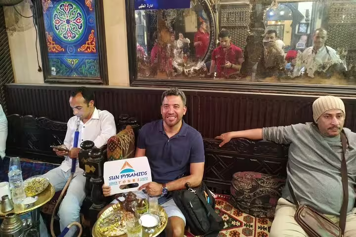 Travelers relaxing at a traditional Cairo cafe with shisha during a tuk tuk tour in Egypt city sightseeing
