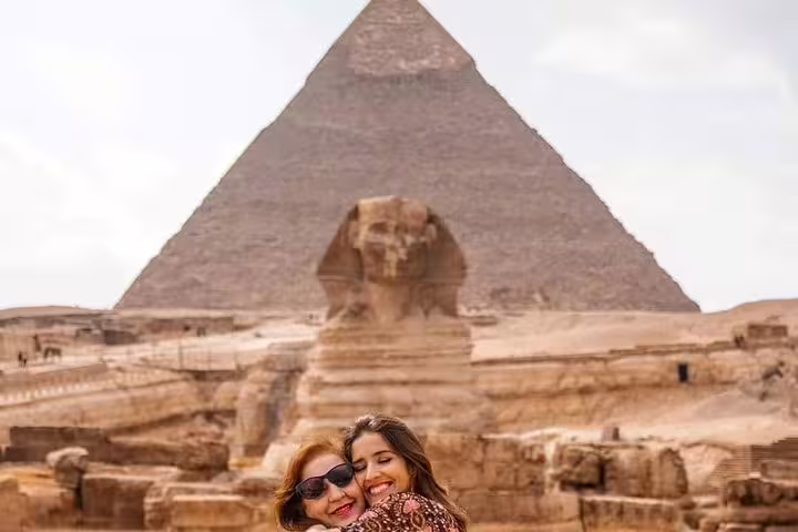 Travelers hug with Great Sphinx and Giza Pyramid backdrop, luxury Cairo pyramids day tour experience
