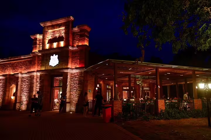 Illuminated Tres Fronteiras Landmark at night, showcasing vibrant architecture and inviting outdoor dining area.
