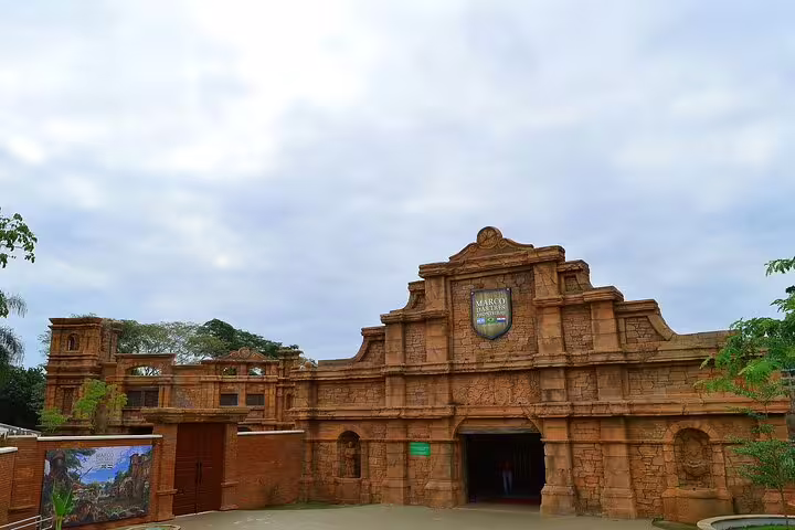Historic stone facade of Tres Fronteiras entrance under a cloudy sky, inviting visitors to explore cultural landmarks.