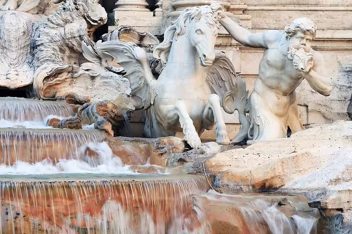 Close-up of Trevi Fountain statues and cascading water in Rome, showcasing baroque details on a guided fountains walking tour