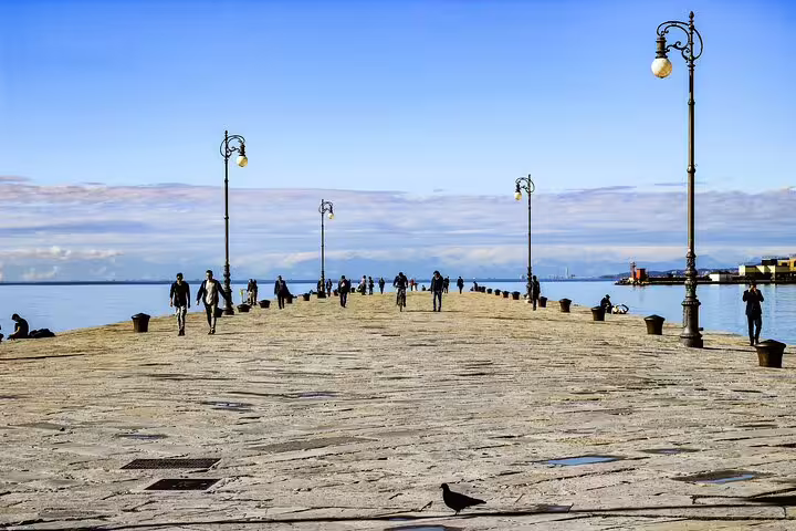 Locals strolling along Trieste’s Molo Audace pier, a scenic stop on the Trieste Hidden Gems private guided walking tour