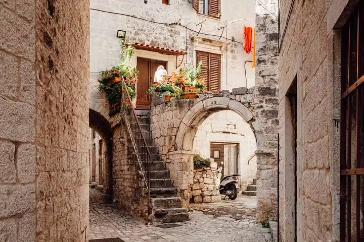 Stone courtyard with archway and stairs in Trogir Old Town, Croatia, seen on a private guided walking tour