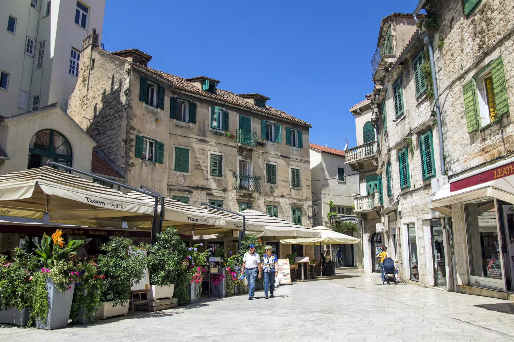 Historic stone street in Trogir old town with cafes and green shutters on Makarska Riviera day trip