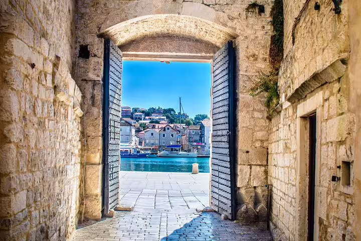 Stone gate opening to Trogir waterfront, scenic stop on Blue Lagoon and 3 Islands speedboat tour