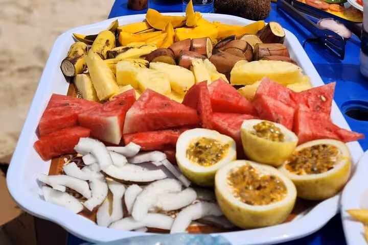 A vibrant platter of tropical fruits like watermelon, pineapple, and passionfruit served on a Zanzibar sunset cruise.