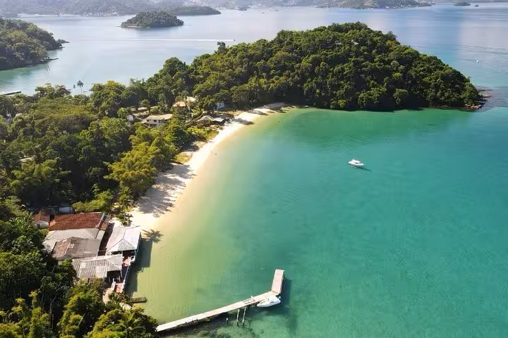 Aerial view of a tropical island with lush greenery and pristine beaches in Angra dos Reis, Brazil.