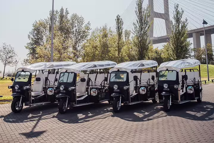 Line of modern tuk tuks ready for a scenic tour in Lisbon's picturesque Belém district.