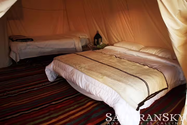 Comfortable interior of a desert tent with cozy bedding, ideal for relaxing after a day of exploring the Tunisia Sahara.