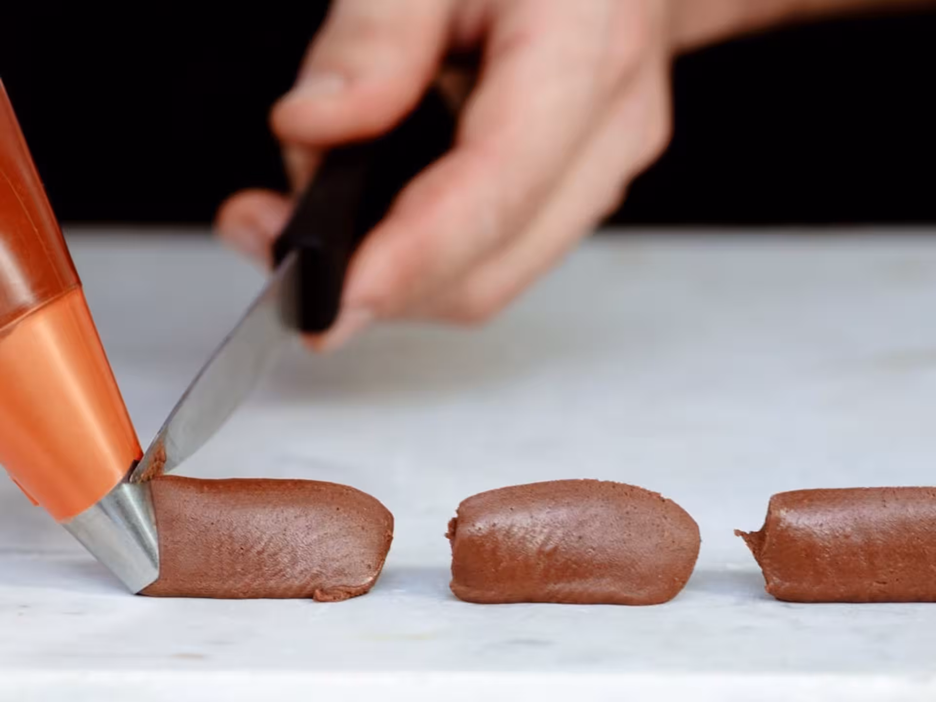Close-up of chocolate being piped and shaped at Turin Chocolate Factory, highlighting the craftsmanship of the tour.