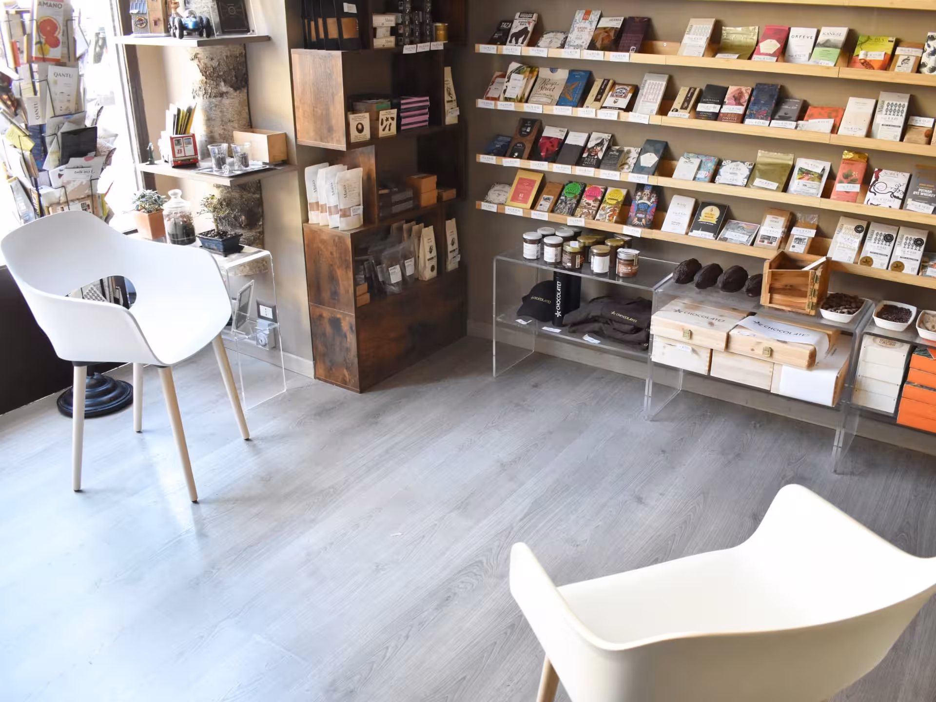 Chic Turin chocolate shop with modern seating and shelves of artisanal chocolate bars and gourmet products.