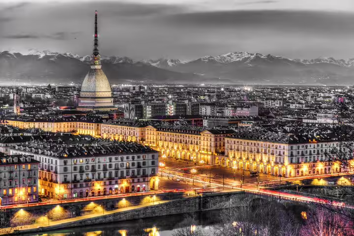 Night view of Turin with illuminated Mole Antonelliana and Po River, perfect for a self-guided scavenger hunt