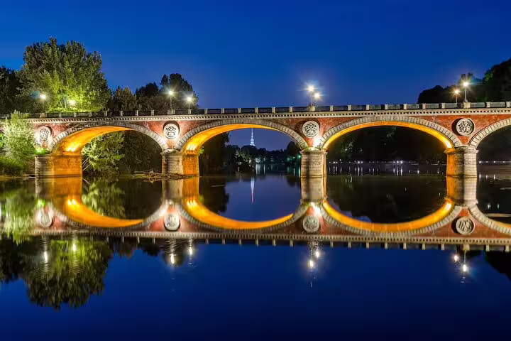Illuminated bridge over the Po River in Turin at night, a romantic stop on a private top sights guided walking tour