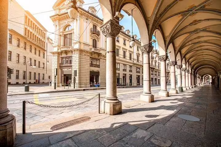 Historic porticoed arcades and elegant palazzi along a quiet central street in Turin seen on a personalized walking tour