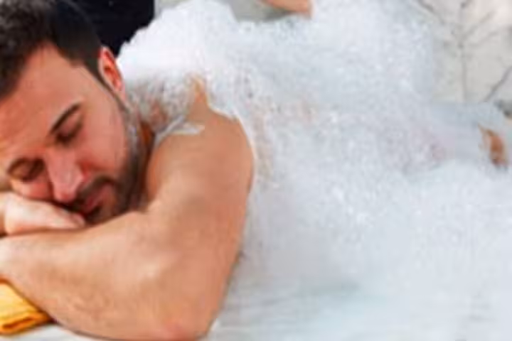 Man enjoying foam wash in Hurghada Turkish bath hammam, a spa package with body massage, sauna, steam and jacuzzi