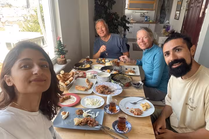 Group enjoying homemade Turkish breakfast spread with tea at a local home after hands-on cooking with locals