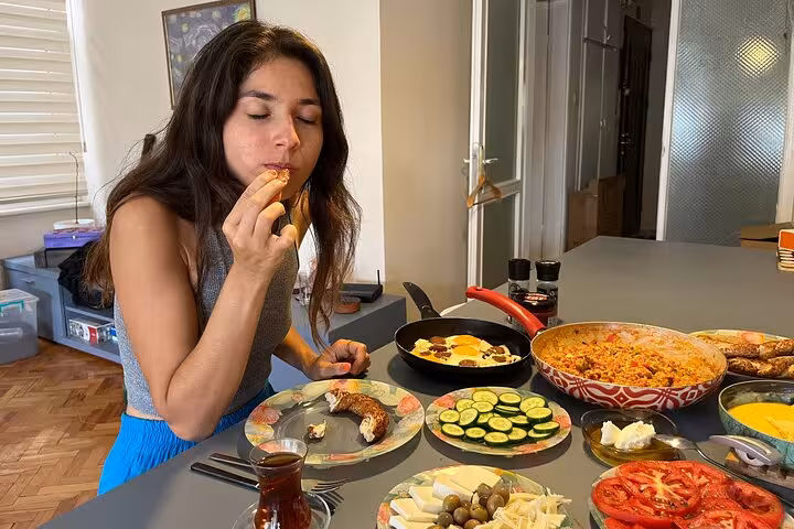 Traveler tasting homemade Turkish breakfast dishes after cooking with local friends, with menemen and fresh plates