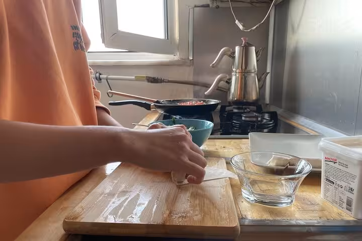 Hands shaping dough on a floured board for homemade Turkish breakfast pastries in a local friends cooking class