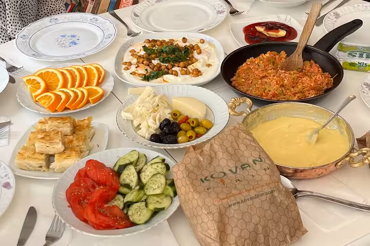Close-up of homemade Turkish breakfast spread with menemen, olives, cheese, börek and fresh salad plates