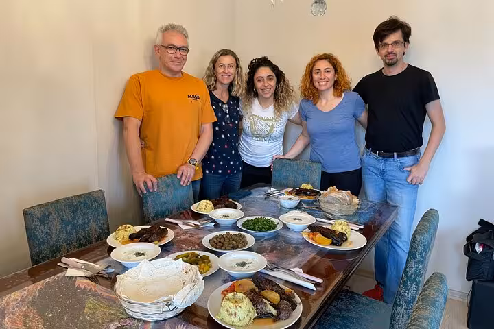 Guests pose with homemade Turkish meze and mains at an authentic Istanbul home cooking class experience