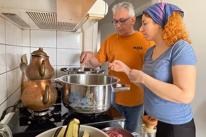 Guests cook Turkish dishes on a stovetop with a local host in an Istanbul home cooking class experience