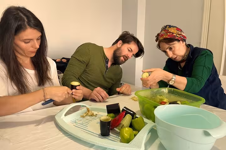 Travelers prep stuffed vegetables with local Turkish moms at a private home cooking class, hands-on lesson