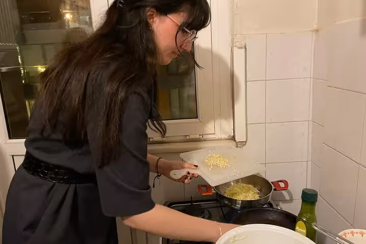 Instructor adding grated vegetables to pan for Turkish meze during beginner cooking class in Istanbul