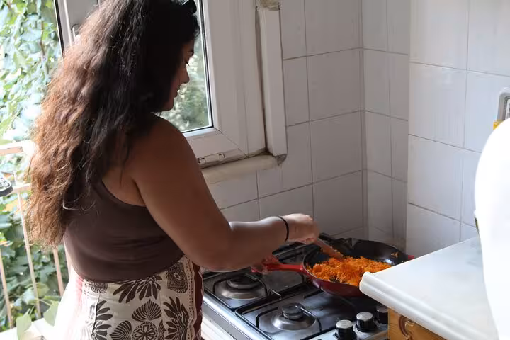 Guest sautéing Turkish meze ingredients on a stove during a beginner cooking class in Istanbul kitchen