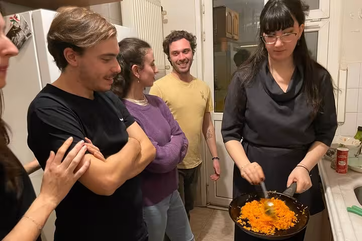 Guests watch the chef sauté carrots during Turkish meze cooking for beginners in an Istanbul home kitchen class