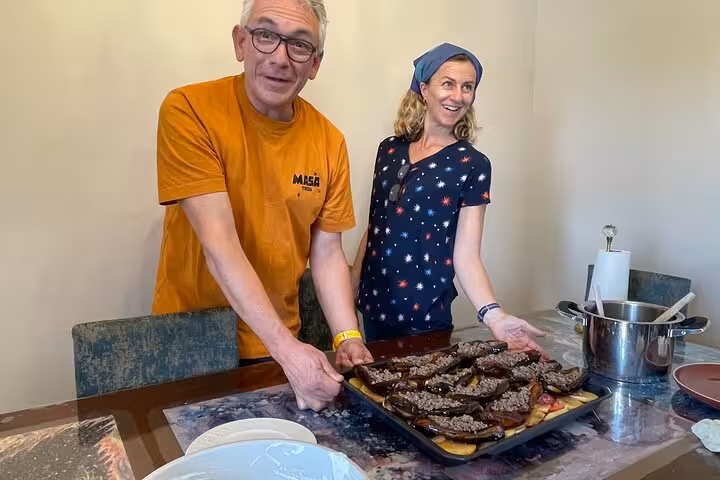 Guests present homemade Turkish stuffed eggplant tray during authentic Istanbul home cooking class experience