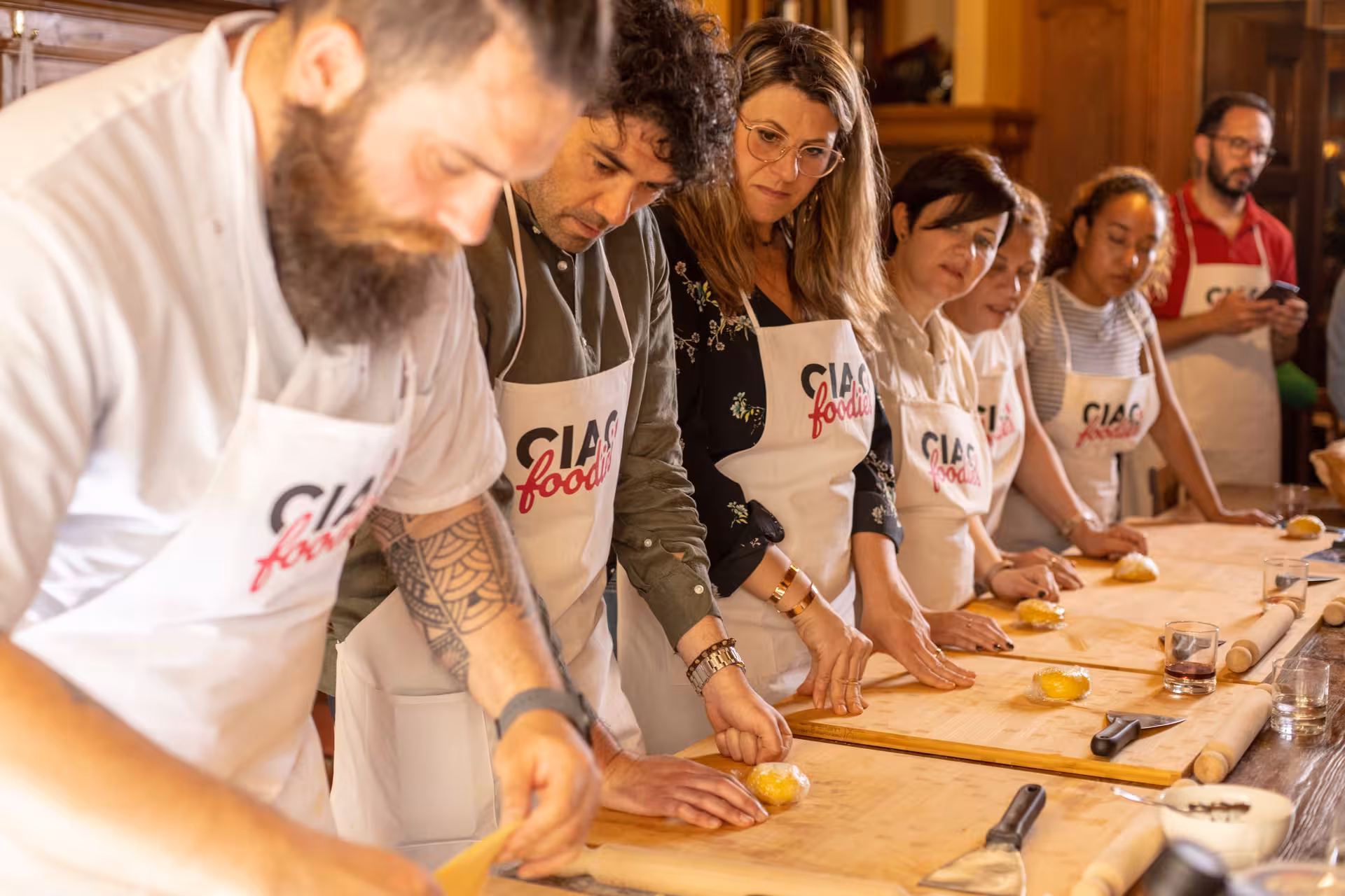 Participants focus on dough preparation in Tuscan cooking class in Florence.