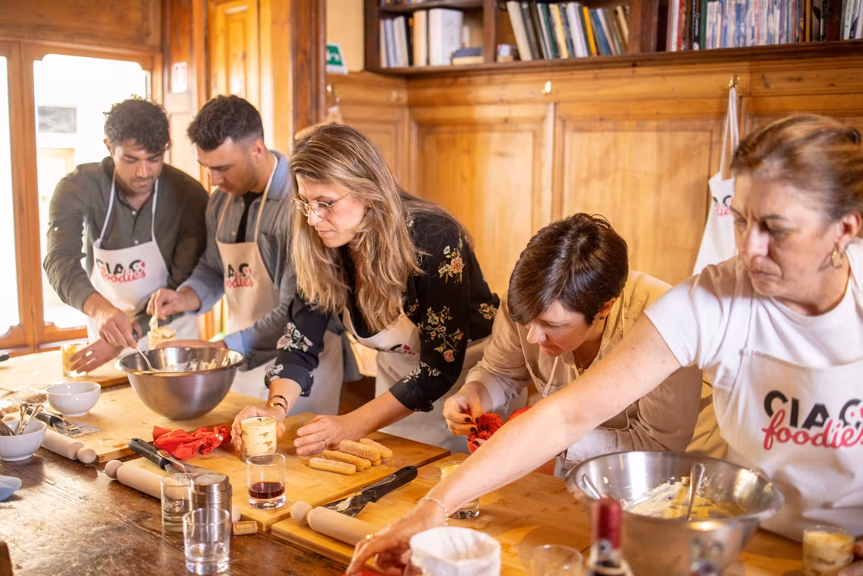 Small group actively engaged in a Tuscan cooking class, learning traditional recipes.