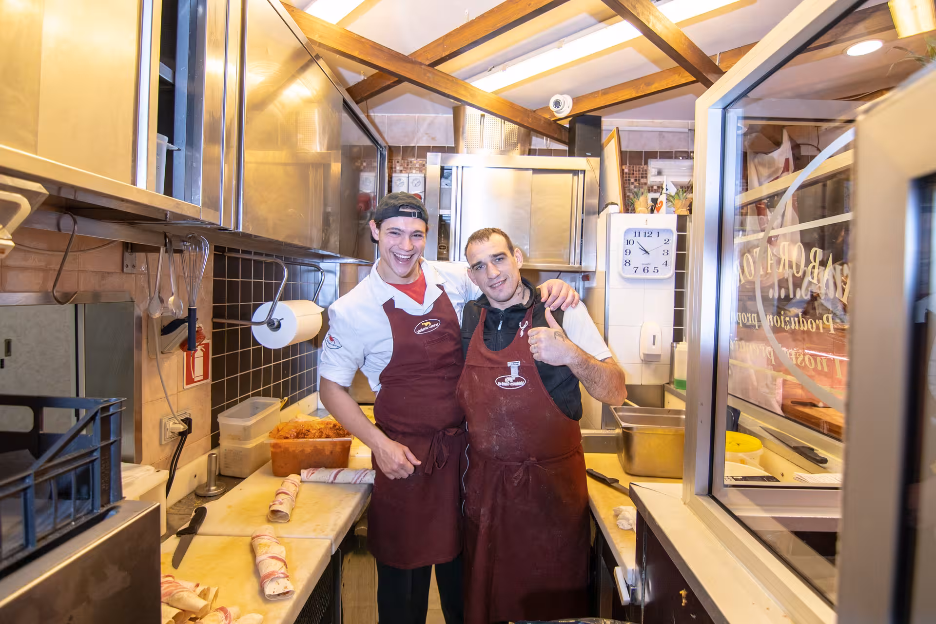 Chefs pose in a Florence kitchen, sharing smiles during the Tuscan Flavors cooking adventure tour.