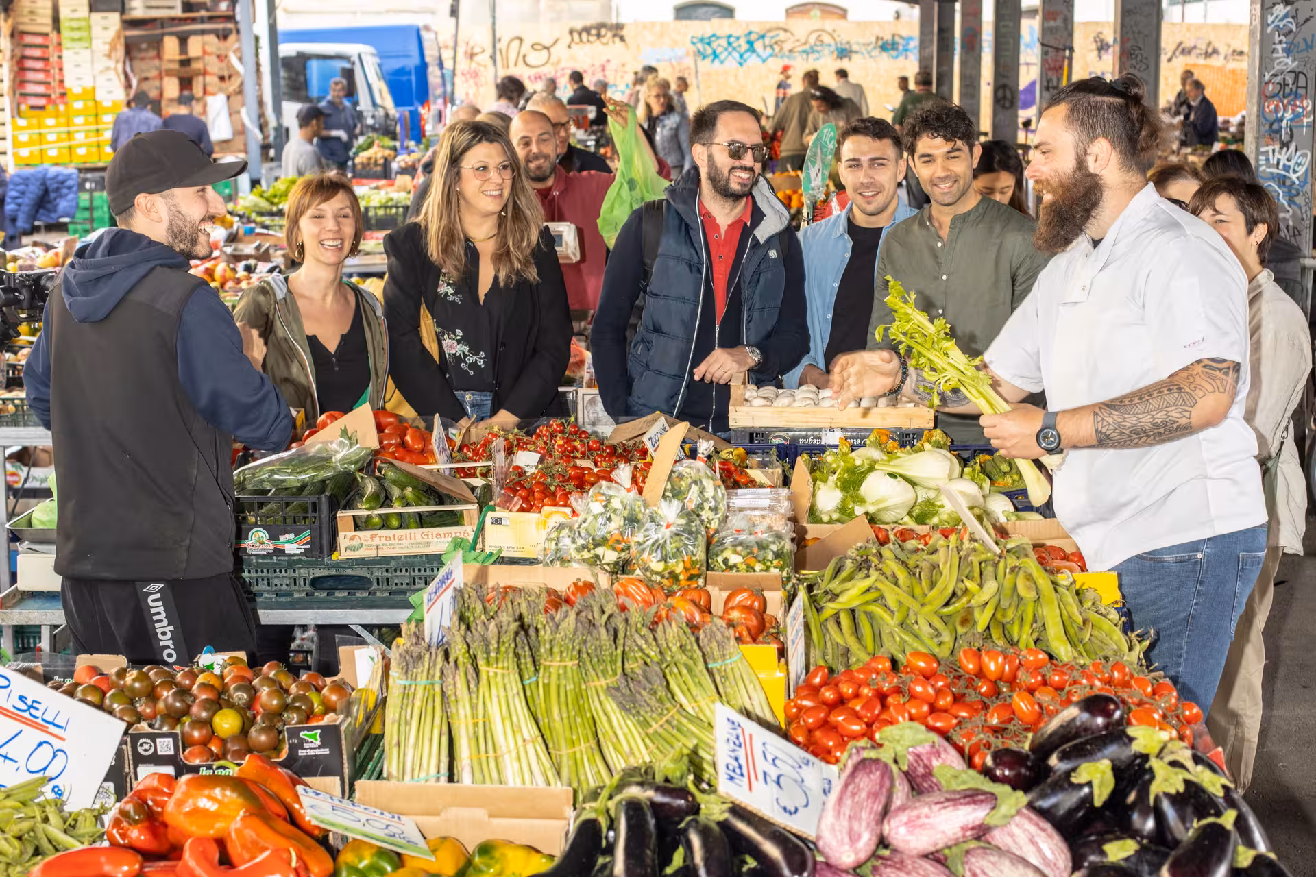 Tour group exploring a vibrant Florence market during the Tuscan Flavors cooking adventure.