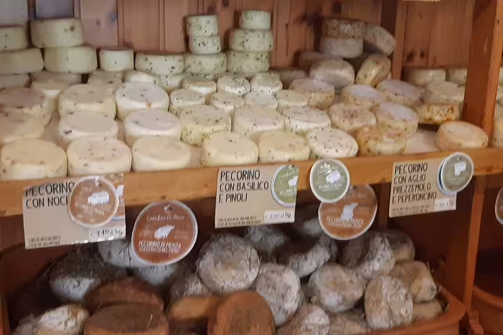 Artisanal Tuscan pecorino cheeses stacked in a rustic Chianti shop, perfect pairing for local wine and cooking classes