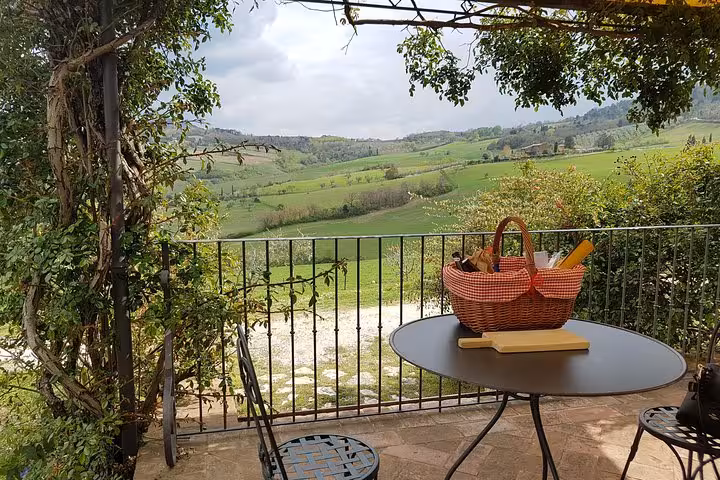 Tuscan terrace picnic with basket and panoramic rolling hills, countryside stop on 10-day Italy tour Rome to Venice