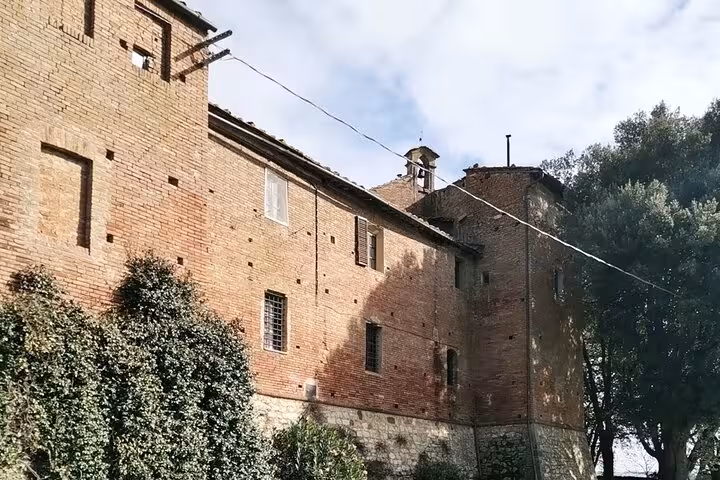 Historic Tuscan villa wall surrounded by greenery, ideal for a cooking class and wine tasting tour from Rome.