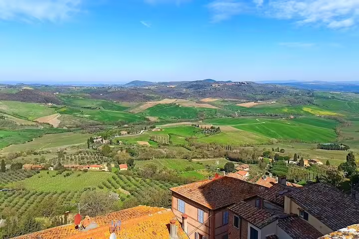 Panoramic view of rolling Tuscan vineyards and medieval rooftops on a Brunello and Vino Nobile private wine tour in Italy