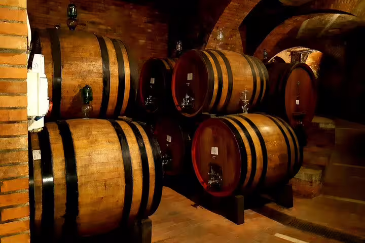 Traditional wooden wine barrels in a Tuscan cellar, where guests enjoy tastings on the private Pisa and Lucca farm tour