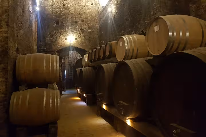 Wine barrels in a historic Tuscan cellar, wine tasting stop on 8-day private medieval villages tour Italy