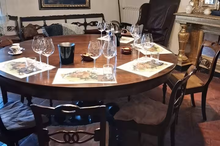 Elegant Tuscan dining setup ready for wine tasting experience in Rome, featuring glasses and rustic decor.