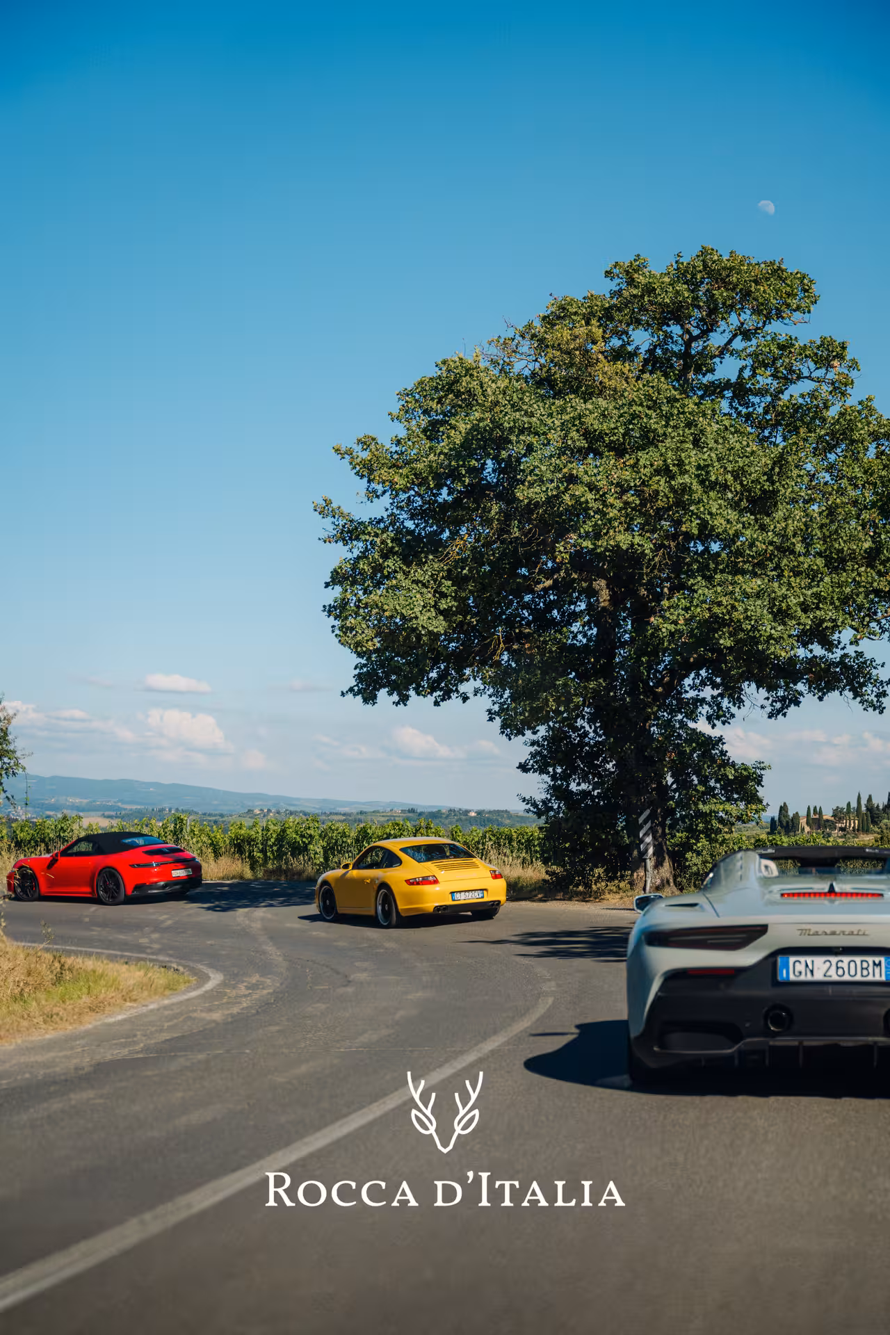 Three supercars navigate a scenic Tuscan road, offering an exhilarating driving experience on the Tuscany Hills tour.