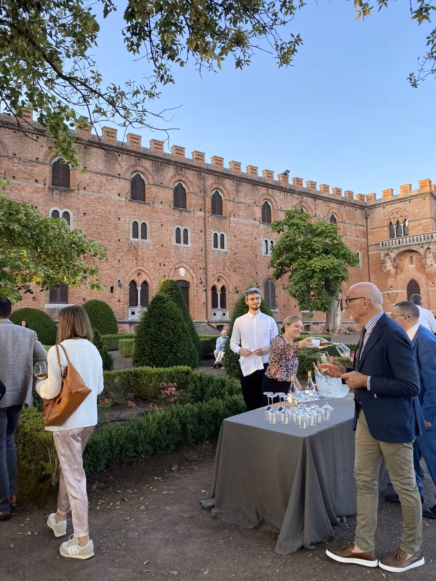 Guests enjoying an elegant outdoor wine tasting in front of a historic Tuscan villa during the Tuscany Hills Experience.