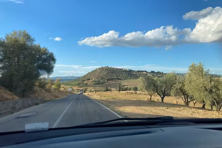 Scenic drive through Tuscany with rolling hills and olive trees on the way to Montepulciano from Rome to Florence.