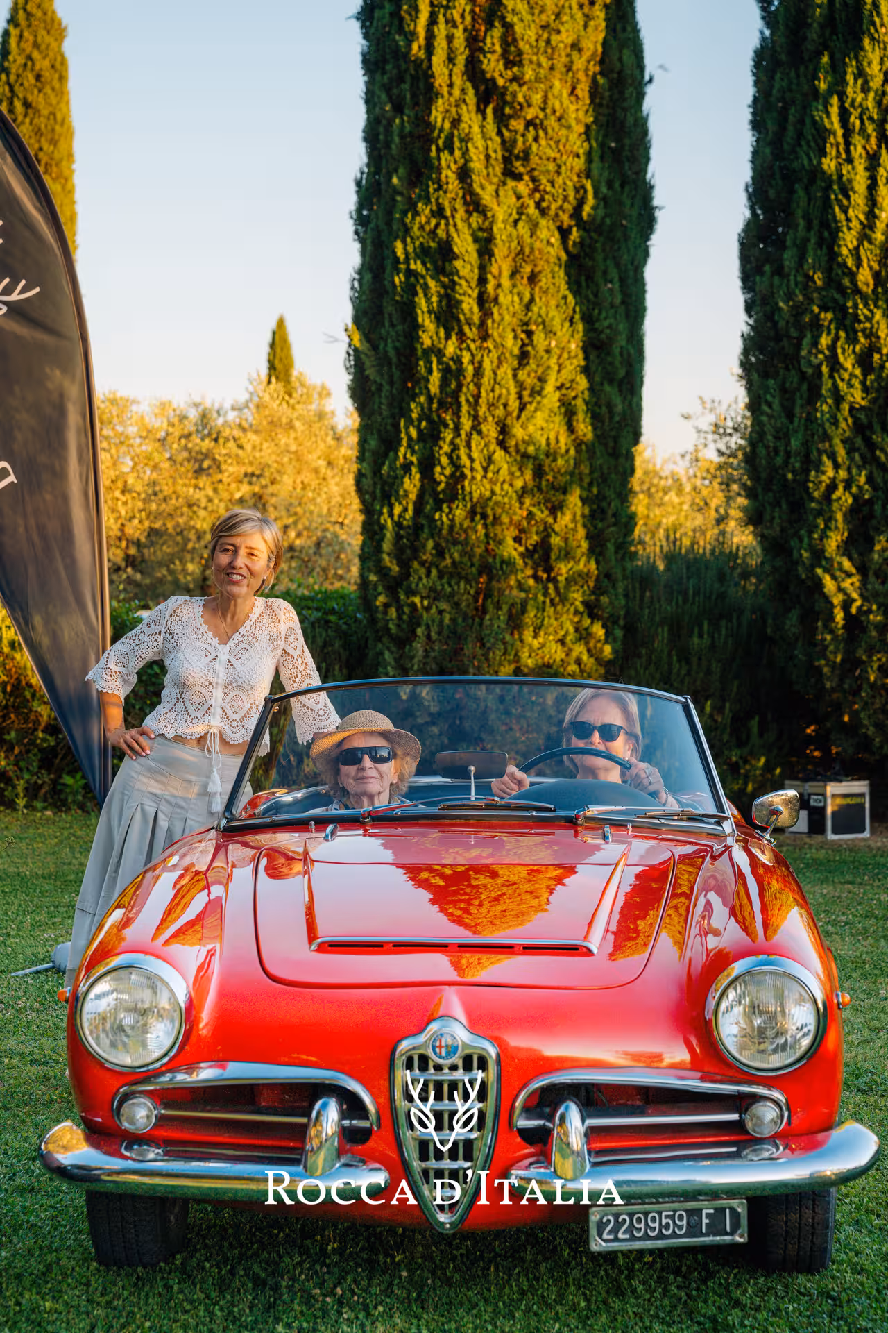 Enjoy a Tuscany supercar adventure with a classic red convertible amidst scenic hills and tall cypress trees.