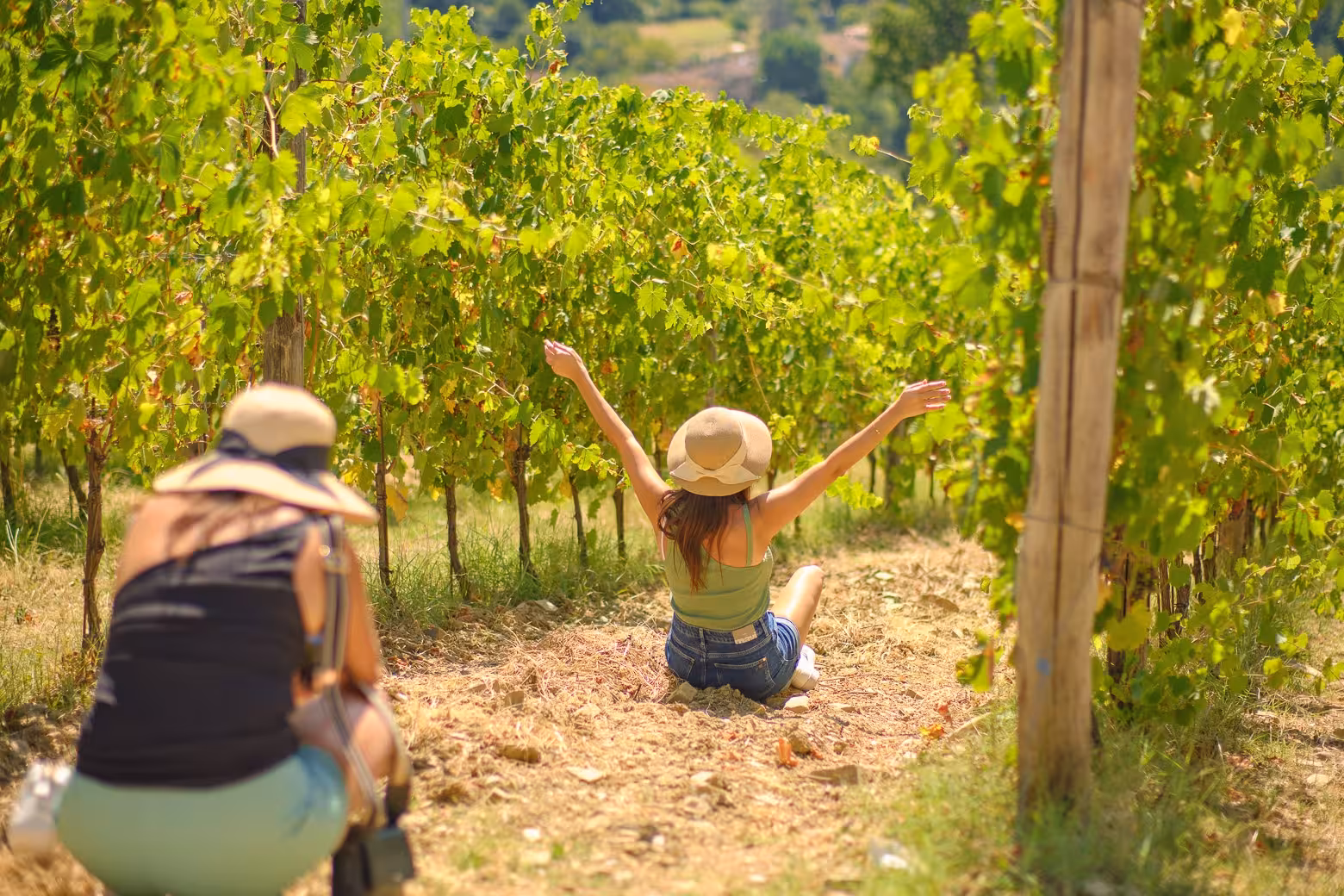 Visitors relax in vibrant vineyards during the Tuscany by Vespa small group tour from Florence.